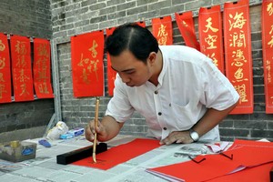 林漢城書法家揮筆送春聯。