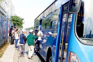 不少乘客在酷熱天氣下站在河內公路上第二郡路段等候巴士。