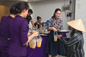 華人女企業家龐美玲向貧困者分發素食餐套。