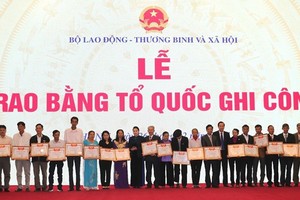 國會主席阮氏金銀向各烈士的家屬頒授“祖國記功”證書。（圖源：PV）