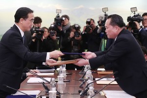 韓方首席代表趙明均（左）和朝方首席代表李善權交換聯合新聞稿。（圖源：AFP）