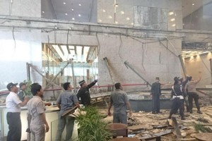 印尼證券交易所的員工及保安人員在檢查底層大廳破損情況。 （圖源：路透社）