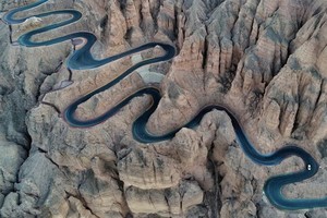 中國甘肅白銀，一輛汽車行駛在景泰縣黃河石林景區的22道彎盤山公路上，空中俯瞰這條盤山公路風景險美。（圖源：互聯網）