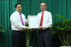 中央組織部長范明政(左)向呂文雄同志頒發出任後江省省委書記職稱批准《決定》。