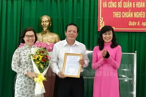 市人委會副主席阮氏秋(右)向第六郡領導頒發“無貧窮戶之郡”《公認決定書》。（圖源：市黨部新聞網）