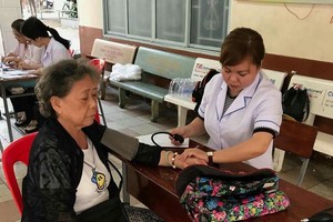 第五郡第七坊婦女會配合坊衛生部門向家境貧困的越華婦女及孤寡長者贈醫施藥。