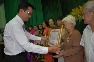 第十一郡領導向胡志堅大娘頒發市人委會獎狀。