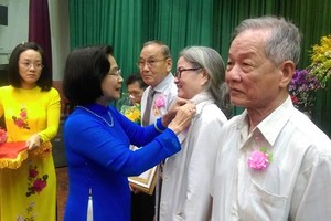 原黨中央委員、原市委副書記阮氏秋霞向第十一郡黨部的黨員授予黨齡紀念章。（圖源：愛珍）