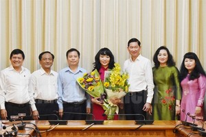 市人委會頒授調動和委任市財政廳副廳長范氏紅霞(中)擔任市國家財政投資公司總經理職務的《決定》，任期5年。（圖源：市黨部新聞網）