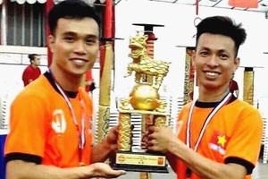 越南精英堂龍獅團捧起冠軍盃。