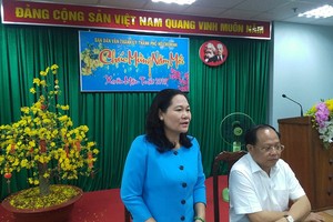 市委常務處委員、民運處主任阮氏麗(左)就市委民運處展開2018戊戌年春節關照情況作出報告。（圖源：市黨部新聞網）