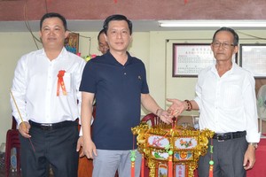 鍾振明理事長移交一本萬利聖燈給 得主勞湧福(中)。