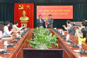 黨中央書記、中央理論委員會主席、胡志明國家政治學院院長阮春勝教授(中左)向國家與法律院副院長張胡海副教授頒發國家與法律院代院長職務的委任《決定》。（圖源：孟勝）