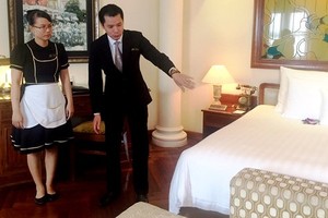 何文雄指引人員整理房間。