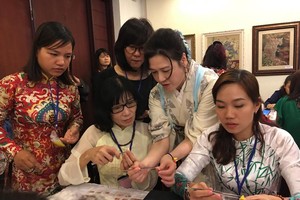 來自日本小布花布料協會的會員親自指引婦女手製日式布花。