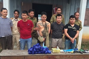 被抓獲的5名老撾籍嫌犯(前排)與涉案贓物綜合毒品、冰毒及其他物證。（圖源：孟雄）