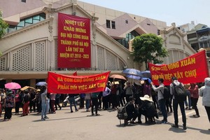 上百名河內市還劍郡同春市場的商販聚眾舉標語抗議。