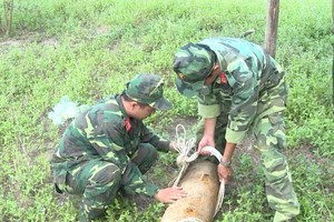 永隆省軍事指揮部的兩名工兵在現場處理戰後遺留的老炸彈。