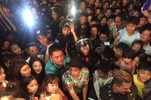 觀眾在一表演場所圍住喜劇演員長江。