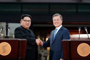 文在寅（右）與金正恩在韓朝首腦峰會記者會後握手合影。（圖源：韓聯社）