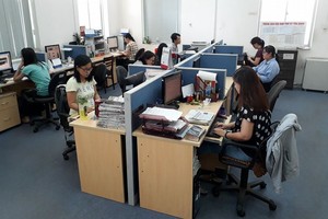 本報編譯員在寬敞的新社址工作。