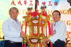 崇正會館理事長鄭鑫發(左)把第一盞 聖燈交給陳添祥先生。