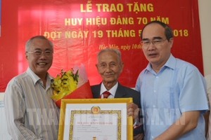 市委書記阮善仁向黎文毅同志頒授70年黨齡紀念章。（圖源：市黨部新聞網）