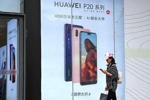 福州市民從華為手機廣告旁經過。