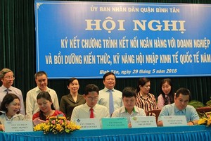 各商業銀行代表與平新郡的各企業家簽署優惠貸款合約。（圖源：黎叉）