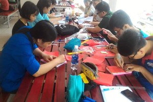 中文與俄文學系的大學生正在市師範大學為高考生製作紀念禮物。