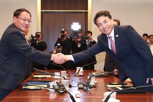 韓國土交通部第二次官金正烈(右)和朝鐵道省副相金潤革握手。（圖源：韓聯社）