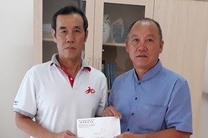 本報時事組組長兼讀者-社會慈善工作組負責人徐國樑(左)向芽莊華人會館會長、廣東會館會長、啟明華文學校重建委員會主席鄭成龍轉交讀者捐助的6040萬元。