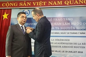 法國駐本市總領事Vincent Floreani向阮玉殿副教授頒授法國政府的翰林院棕櫚葉勳章。（圖源：PLO）