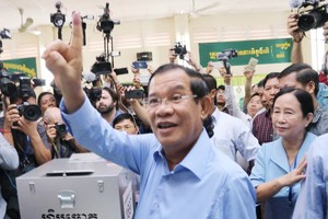 洪森在柬干拉省大金歐市大金歐分區投票點伸出已“投票印記”的右手食指。（圖源：互聯網）