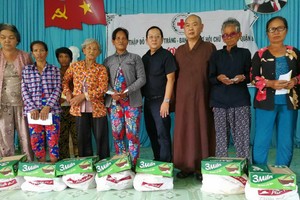 釋慧功法師（右三）和華人企業家麥漢強（右四）贈送禮物給視障者。