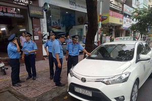 交通監察員在處理一起違規的“野雞”計程車。（圖源：N.Tân）