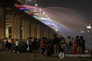 市民觀看噴泉表演消暑納涼。（圖源：韓聯社）