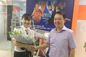捷星太平洋航空公司代表向女機長黎氏碧紅（左）頒發機長證書並贈送鮮花祝賀。