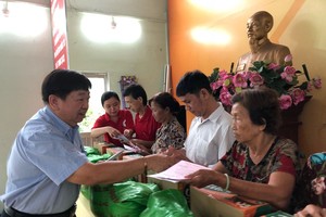 張子諒理事長贈送扶助金和禮物給越華長者。