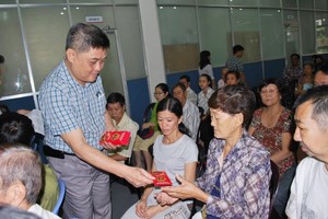 梁栢滔派發現金協助病人治病。