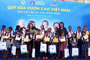 國家副主席鄧氏玉盛向平定省洪水區的學生贈送禮物和奶品。