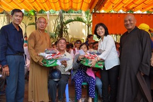 龍華寺住持釋慧功（左二）向窮人派發禮物。