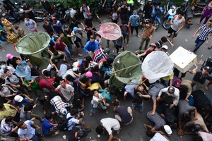 “拜幽靈”後撒錢的陋習引來眾人爭搶著撿錢。（示意圖源：互聯網）