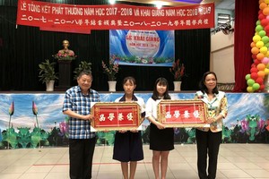 杭慰瑤董事長(左一)頒獎牌給品學兼優的學生。 