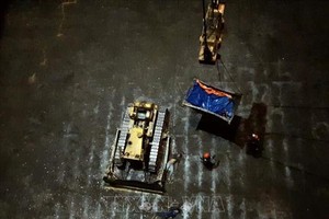 職能力量趕赴事發現場勘查死因並將2名死者送出船艙。（圖源：越通社）