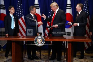 韓總統文在寅（左）和美總統特朗普交換韓美FTA修訂案文件。（圖源：AP）