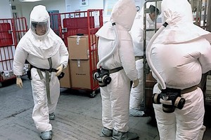 穿著生化防護衣人員2日在國防部郵件處理中心過濾郵件和包裹。（圖源：AFP）