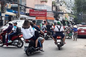 很多少兒坐摩托車時不戴安全帽。