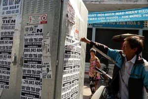 民眾拆除違法張貼的免抵押貸款廣告。（圖源：自忠）