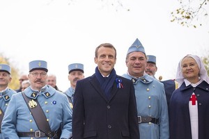 11月5日，法國莫朗格，法國總統馬克龍在當地的戰爭紀念館與身穿復古軍裝裝扮成一戰法國士兵的歷史愛好者合影。莫朗格戰爭紀念館當日舉行致敬儀式，慶祝第一次世界大戰結束一百週年。（圖源：互聯網）